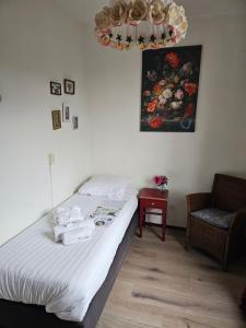 1 dormitorio con 1 cama, 1 silla y 1 pintura en Stee in Stad, en Groninga