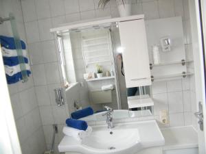 Baño blanco con lavabo y espejo en Ferienwohnung Seeblick - b47745, en Neuharlingersiel