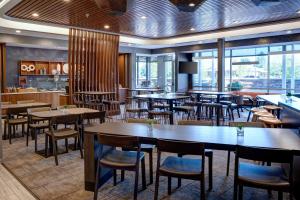 グランビルにあるSpringHill Suites by Marriott Grand Rapids Westのテーブルと椅子、窓のあるレストラン