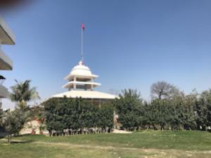 un edificio con una torre en medio de un campo en Vedic Villa,Varanasi, en Varanasi