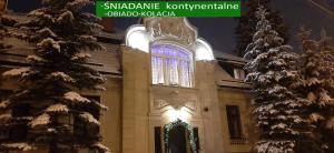 a building with a christmas tree in front of it at Dworek pod świerkami in Jelenia Góra