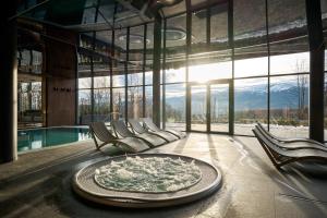 um quarto com cadeiras e uma piscina com uma mesa em Złoty Horyzont Hotel & Resort Szklarska Poręba em Szklarska Poręba