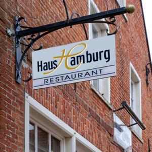 Restaurant Haus Hamburg في لير: علامة على جانب مبنى من الطوب