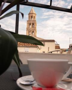 a white bowl sitting on a table with a clock tower at Slavija Culture Heritage Hotel in Split