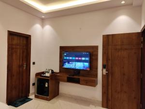 a room with a flat screen tv on a wall at Emerald Suites in Greater Noida