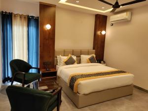 a bedroom with a bed and a desk and a chair at Emerald Suites in Greater Noida