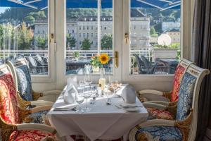 una sala da pranzo con tavolo, sedie e finestre di Häcker's Hotel a Bad Ems