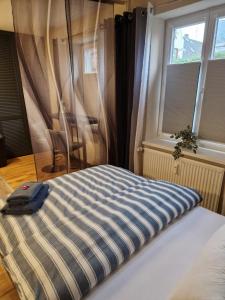 un letto in una camera con due finestre di Katrins-Wohntraum a Rendsburg