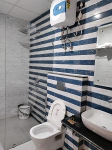 a bathroom with a toilet and a sink at Emerald Suites in Greater Noida