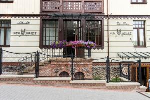 a building with a balcony with flowers on it at Villa Mozart in Truskavets