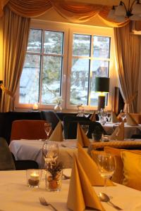 una sala da pranzo con due tavoli, bicchieri e finestre di Landhaus Silberberg a Winterberg