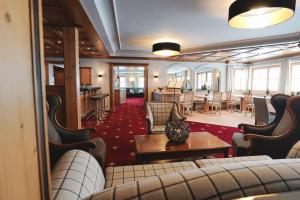 a waiting room with couches and a table and chairs at Hotel Acerina Superior in Lech am Arlberg