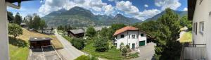 una casa en una colina con montañas en el fondo en Grosse, schöne Wohnung im Grünen, en Brig