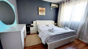 una camera con letto bianco e specchio di Signature Idea hotel a Tirana