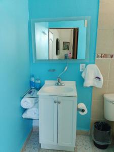 a blue bathroom with a sink and a mirror at Casa las Flores in Puerto Vallarta