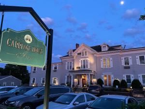 un cartello di fronte a una grande casa di The Carriage House Inn Newport a Middletown