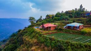 una casa en la cima de una colina con una granja en Lifeline Villas - Miracle 5BHK Infinity Pool Villa With Breathtaking Valley View And Huge Lawn Area, en Mahabaleshwar