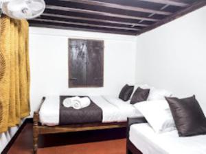 a bedroom with two beds and a window at Keloth Tharavad Kerala in Panamaram