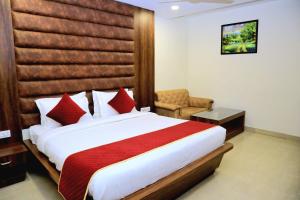 1 dormitorio con 1 cama grande y 1 silla en Pineberry Hotels - Near Golden Temple, en Amritsar