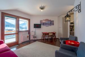 a living room with a couch and a table and a window at [SESTRIERE] Appartamento sulle piste in Sestriere