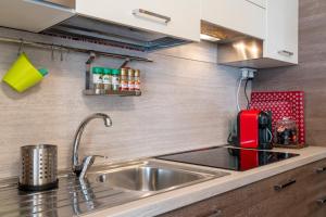 a kitchen with a sink and a red appliance at [SESTRIERE] Appartamento sulle piste in Sestriere