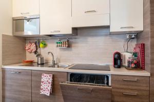 a kitchen with white cabinets and a sink at [SESTRIERE] Appartamento sulle piste in Sestriere