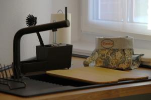 a kitchen counter with a cutting board and a sewing machine at Ferienwohnung Emma in Jork