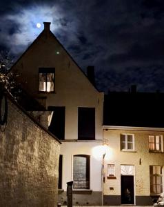 ein großes weißes Haus mit einem Mond am Himmel in der Unterkunft Hamiltonhouse in Brügge