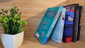 une rangée de livres à côté d'une plante en pot dans l'établissement Ferienwohnung AS 5 One & Two Bamberg - Parkplatz, Balkon, à Hallstadt