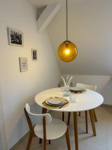 une salle à manger avec une table et des chaises blanches dans l'établissement Ferienwohnung AS 5 One & Two Bamberg - Parkplatz, Balkon, à Hallstadt