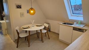 une petite cuisine avec une table, des chaises et un évier dans l'établissement Ferienwohnung AS 5 One & Two Bamberg - Parkplatz, Balkon, à Hallstadt