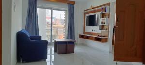 sala de estar con silla azul y TV en NMS GRAND VIEW TOWER, en Pondicherry