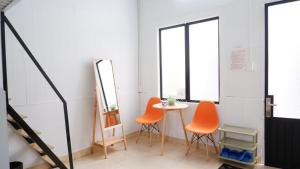 une chambre avec trois chaises orange et une table dans l'établissement 296 Cetete - Home in Dalat, à Đà Lạt