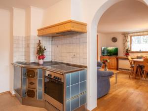 uma cozinha com fogão forno superior ao lado de uma sala de estar em apartment Johann in Wald im Pinzgau with balcony em Wald im Pinzgau