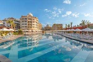 uma piscina num resort com cadeiras e guarda-sóis em Kirman Belazur Resort & Spa em Belek