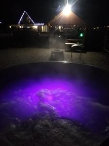 een hot tub 's nachts met paarse verlichting bij Casa Boila in Bîrsana