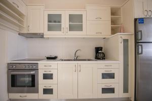 a kitchen with white cabinets and a stainless steel refrigerator at Nereides Luxury Villas in Káto Almirí