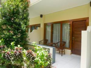 Casa con porche con mesa y sillas en Marine Bay Sanur, en Sanur