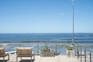 um deque com cadeiras e vista para o oceano em Vitaminas - Casa de Playa y Café em Punta del Este