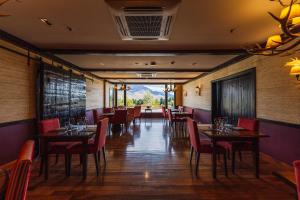 a restaurant with tables and chairs and a view at Loi Suites Chapelco Hotel in San Martín de los Andes