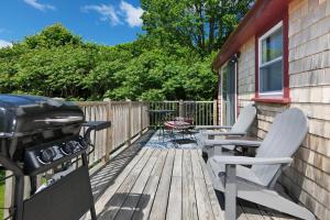 eine Terrasse mit 2 Stühlen und einem Grill in der Unterkunft Cozy Pond Side Cottage in Bar Harbor! [The Nook] in Bar Harbor