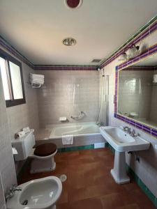 een badkamer met een toilet, een bad en een wastafel bij Moon Dreams El Cortijo in Matalascañas