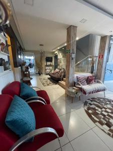 a living room with a red couch and a red chair at Pousada Quedas D'água in Foz do Iguaçu