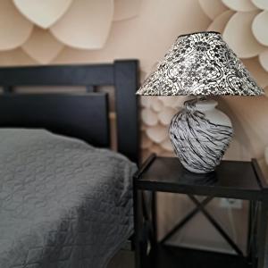 a lamp on a table next to a bed at Apartment on Tytova 8 in Dnipro