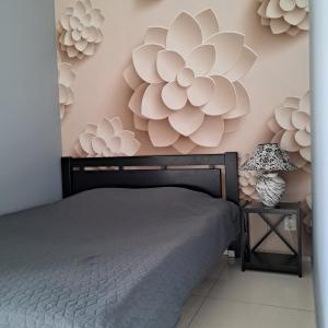 a bedroom with a bed and flowers on the wall at Apartment on Tytova 8 in Dnipro