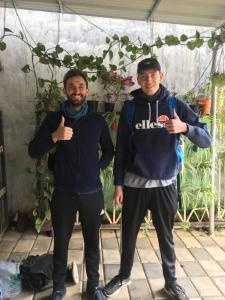 two men standing under a tent giving thumbs up at SpiceGreen Homestay,Thekkady in Thekkady