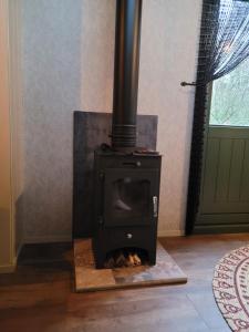 a black stove in a room with a fireplace at B&B 't Maartensdijkse Bos in Maartensdijk