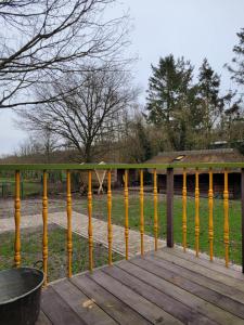 a wooden deck with yellow railing on a yard at B&B 't Maartensdijkse Bos in Maartensdijk