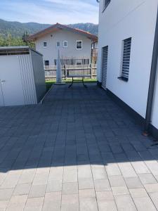 un patio con un banco en el lateral de un edificio en Ferienwohnungen Mountainfloor - Chiemgau Karte, en Inzell