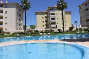 an empty swimming pool in front of buildings at Da Praia Apartment - Pool & Tenis in Vilamoura